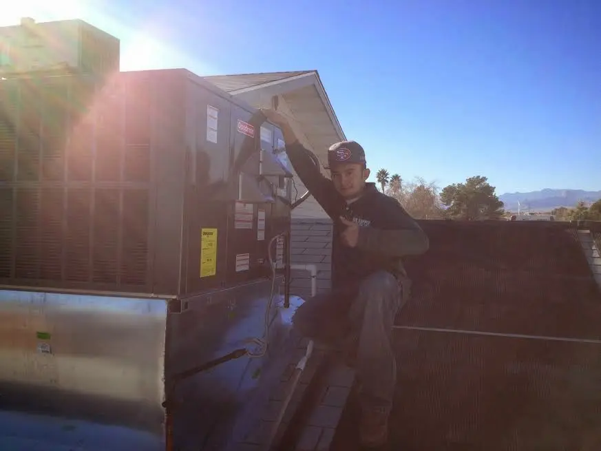 HVAC technician performing AC Tune-Up on a rooftop unit in Chester